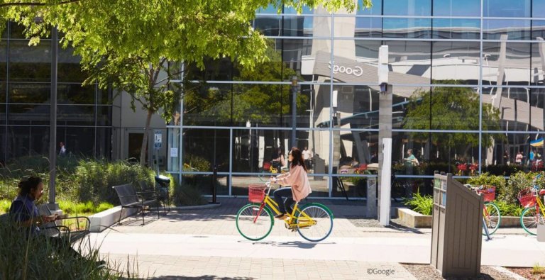 Dame som sykler på fargerik sykkel utenfor Googles hovedkvarter